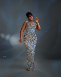 Mo Bimpe posing in a fitted silver metallic gown for her triplets thanksgiving reception in Lekki Lagos.
