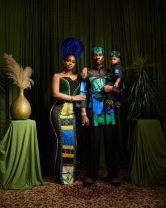 Priscilla Ojo, Juma Jux holding baby Rakeem in matching black and teal outfits.