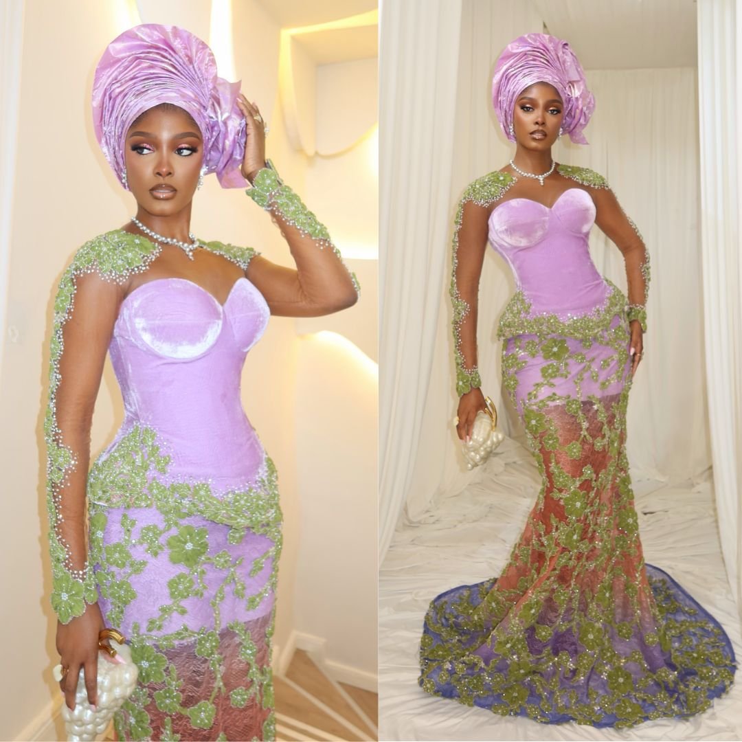 Teminikan wearing a lavender velvet corset dress with sheer green beaded long sleeves, a floral lace train, and a metallic lilac Gele at Akin Faminu traditional wedding.