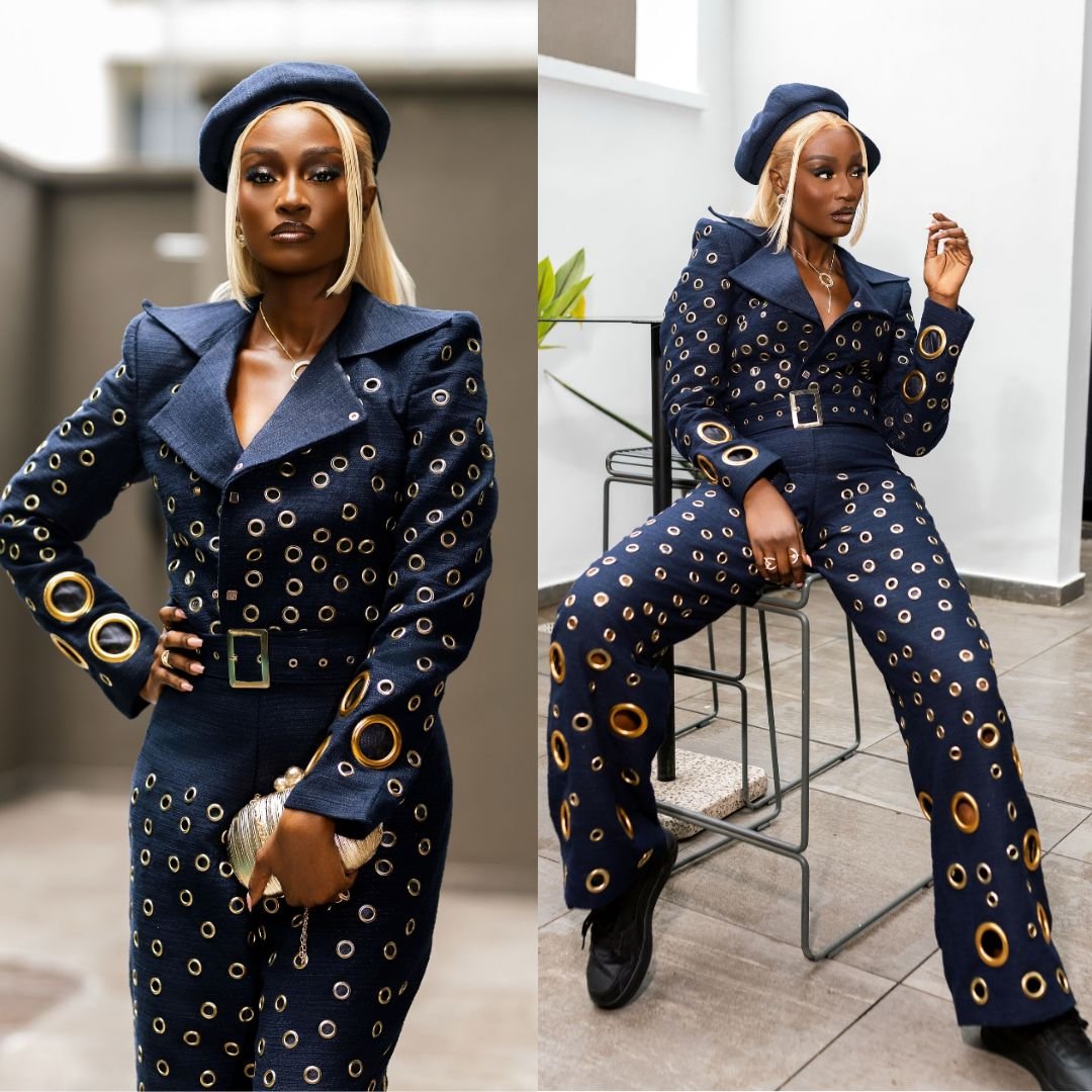 Scarlet Gomez wearing a cropped indigo denim jacket with gold eyelets and wide-leg trousers paired with a dark denim beret. 