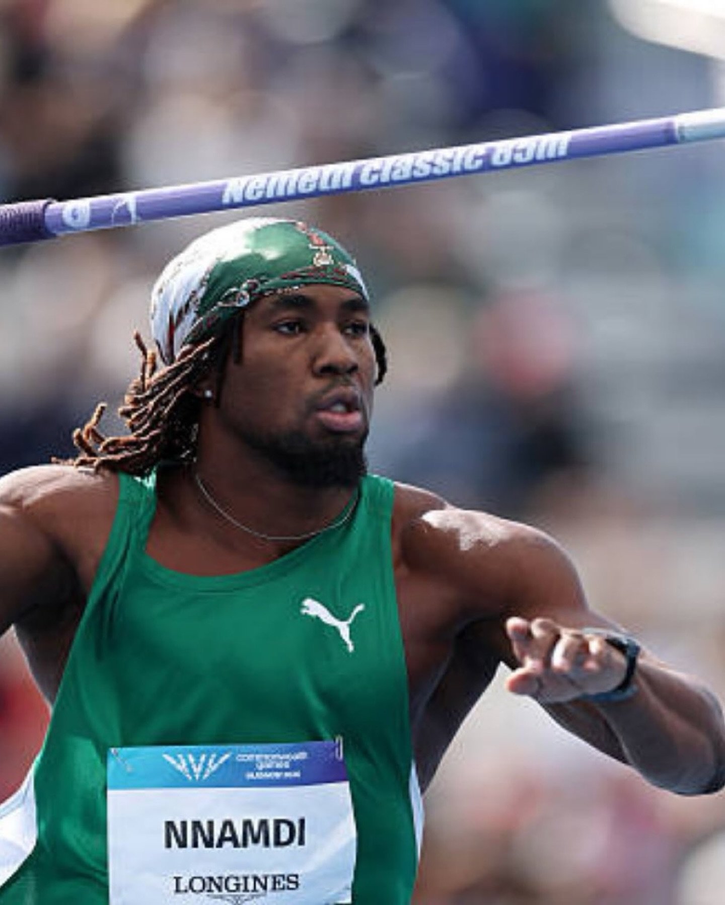 Chinecherem Nnamdi preparing to throw the javelin in a green Nigeria athletics jersey and headband.