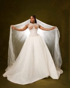 Veekee James in a full white basque-waist ballgown with an embellished corset