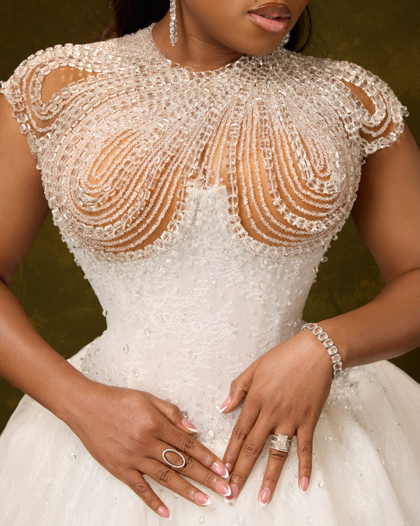 Swirling crystal beadwork on a sheer bodice with a diamond wedding ring and tennis bracelet