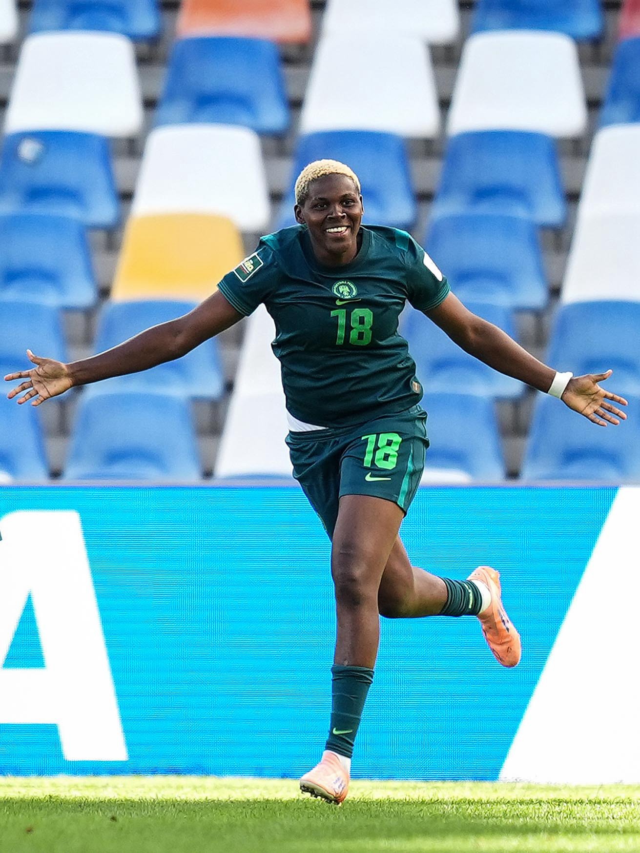 Nigeria forward Seimeyeha Janet Akekoromowei running with arms outstretched after scoring against England.