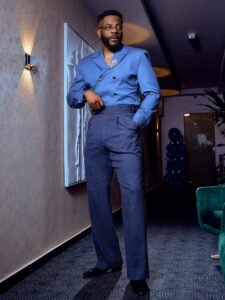 Ebuka Obi-Uchendu wearing a periwinkle double-breasted crossover shirt-jacket with navy pinstripe Gurkha trousers by Atafo.