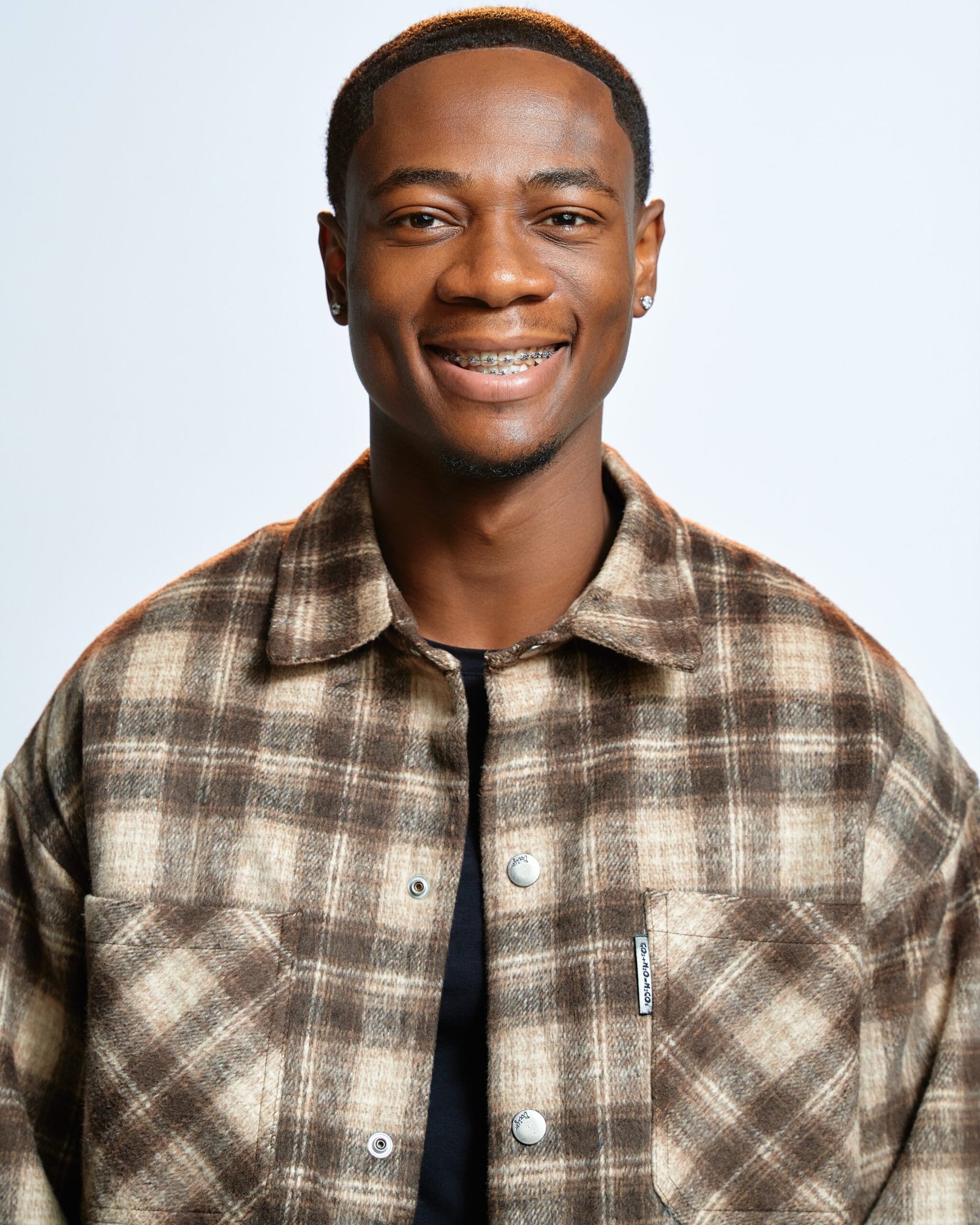 BBNaija Season 11 finalist Tram smiling in a brown patterned shirt