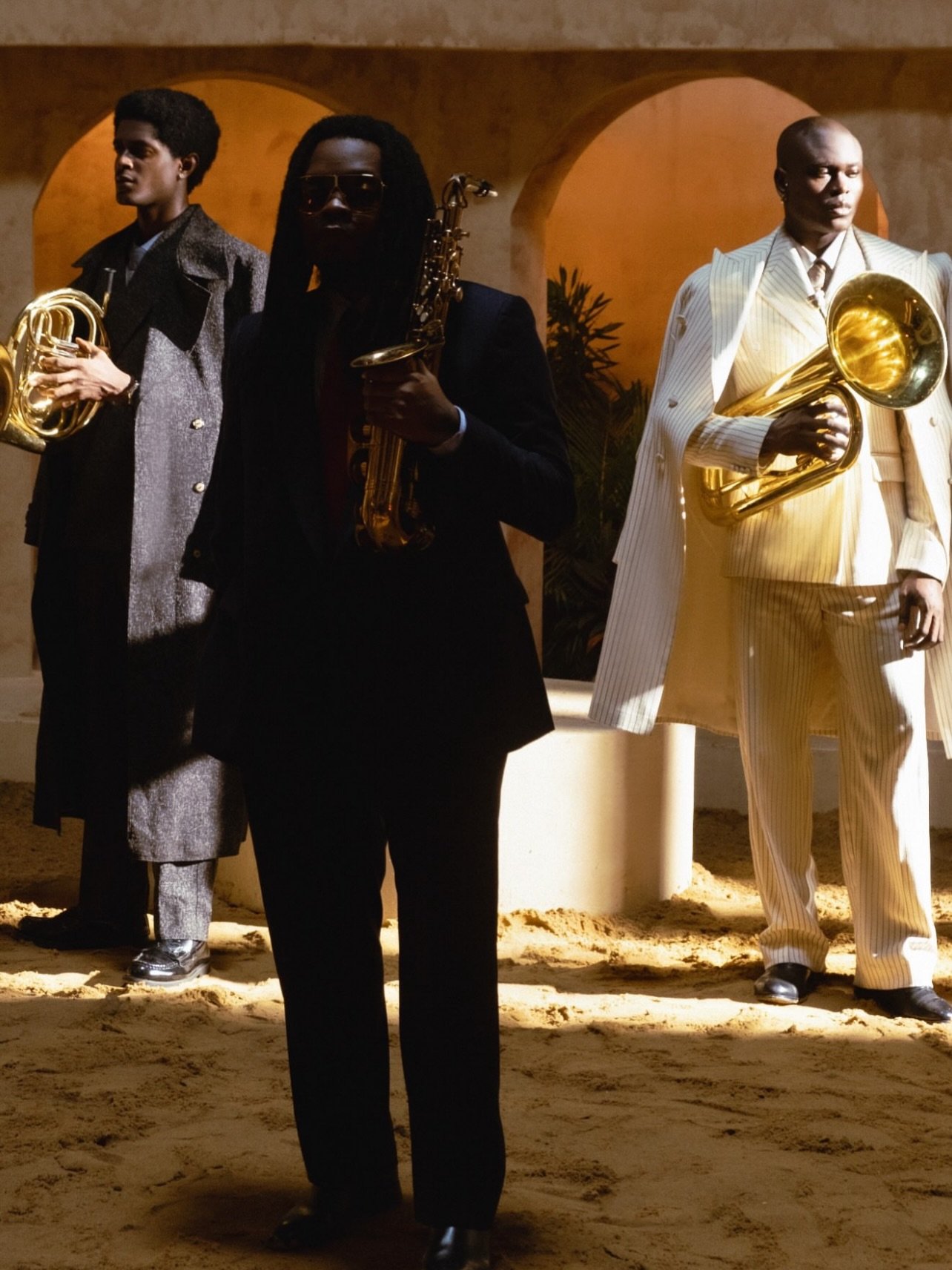 Olamide holding a saxophone alongside brass musicians on the set of his Burukutu music video directed by TG Omori.