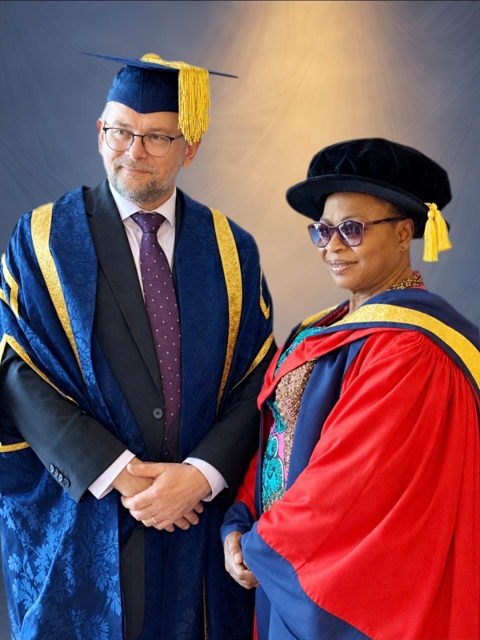 Folorunso Alakija wearing a red academic gown alongside Vice-Chancellor Professor David Cole in ceremonial robes.